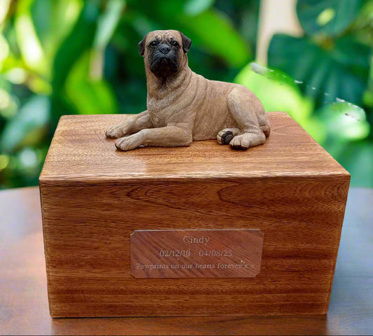 Wooden pet urn with a bullmastiff figurine on top, placed indoors.