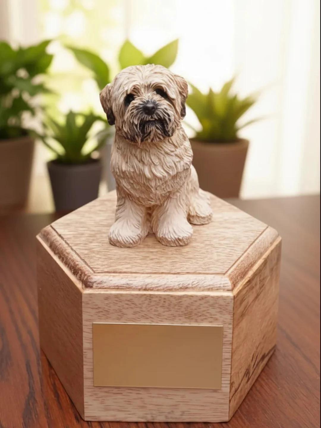 Wooden pet urn with a Gold Lhasa Apso dog figurine on top, set against a blurred indoor background with plants.