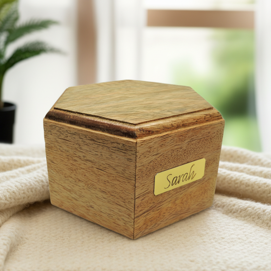 A wooden pet cremation urn with a secure bottom opening, featuring an engraved name plate.